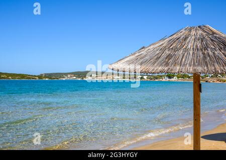 Parapluie de paille à la plage de Xifara, une petite plage calme situé dans la baie de Naoussa sur l'île de Paros, Cyclades, Grèce Banque D'Images