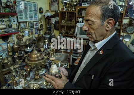 16 juin 2021, Irak, Mossoul : le Fakhri Suleiman Al-Tai irakien est détenteur d'un chandelier dans le cadre d'une collection d'antiquités qu'il a rassemblées après son retour dans la vieille ville de Mossoul après sa libération de la soi-disant organisation terroriste de l'État islamique (EI). Al-Tai a décidé de convertir sa maison en musée temporaire où il expose plus de 5,000 pièces reflétant l'héritage et l'histoire de Mossoul, qui a été gravement endommagé entre 2014 et 2017 sous le règne de l'État islamique. Al-Tai a dépensé près de 33,000 dollars US à la poursuite de sa passion pour recueillir et préserver des pièces de tout le passé Banque D'Images