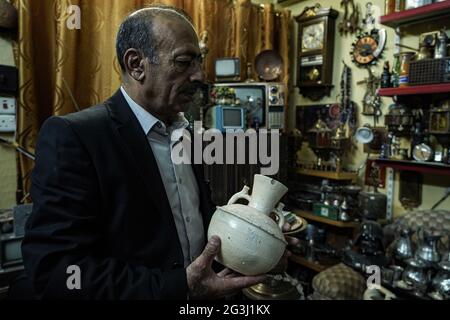 16 juin 2021, Irak, Mossoul: L'irakien Fakhri Suleiman Al-Tai détient une poterie appartenant à l'héritage kurde dans le cadre d'une collection de pièces anciennes qu'il a rassemblées après son retour dans la vieille ville de Mossoul après sa libération de la soi-disant organisation terroriste de l'État islamique (EI). Al-Tai a décidé de convertir sa maison en musée temporaire où il expose plus de 5,000 pièces reflétant l'héritage et l'histoire de Mossoul, qui a été gravement endommagé entre 2014 et 2017 sous le règne de l'État islamique. Al-Tai a dépensé près de 33,000 dollars US à la poursuite de sa passion pour le coll Banque D'Images