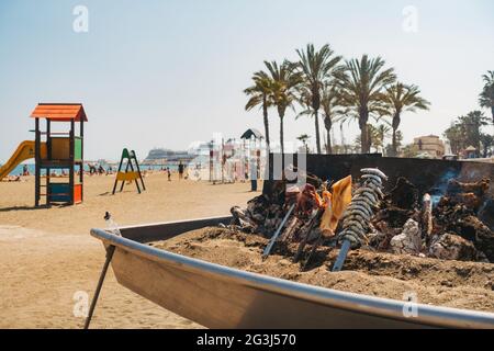 Une variété de fruits de mer cuisent sur un barbecue au feu de bois de fortune dans un restaurant sur la plage de Malagueta, Málaga, Espagne Banque D'Images