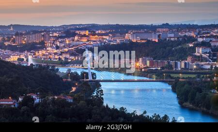 Vue panoramique de Coimbra au crépuscule, au Portugal, avec la rivière Mondego et le pont Rainha Santa Isabel au premier plan. Banque D'Images