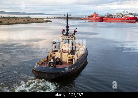 harbour Tung Fidra, remorquage d'un bateau de croisière hors du bassin de Leith, Édimbourg, Écosse, Royaume-Uni Banque D'Images