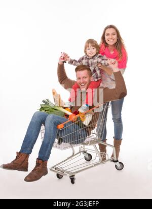 Famille heureuse avec un panier de supermarché Banque D'Images