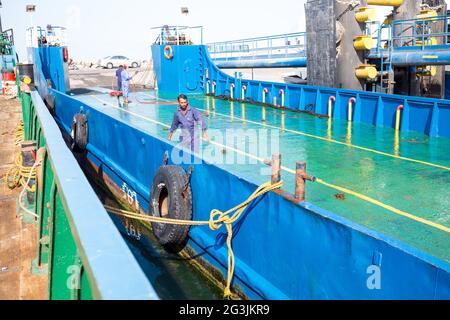 Ferry de Masirah, Oman; hommes nettoyant le pont d'un ferry local qui transporte des véhicules et des marchandises entre l'île et le continent Banque D'Images