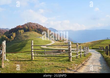 Paysage d'automne des Alpes pittoresques, clôture en bois et collines de montagne en Lombardie, Italie. Banque D'Images