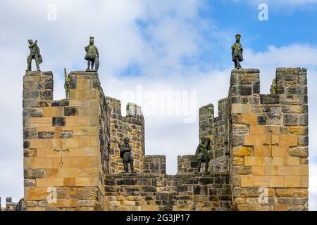 ALNWICK, ANGLETERRE - 10 JUIN 2021 : statues de guerriers sur le sommet du barbican, maison d'entrée du château d'Alnwick, Northumberland, Angleterre Banque D'Images