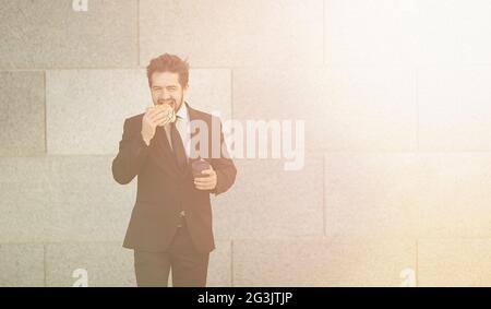 Businessman eating and drinking sur d'aller Banque D'Images