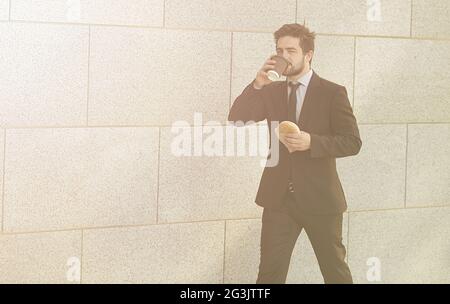 Businessman eating and drinking sur d'aller Banque D'Images