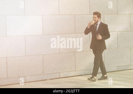 Businessman eating and drinking sur d'aller Banque D'Images