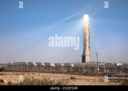 Centrale solaire Ashalim dans le désert du Néguev. Les miroirs réfléchissants réglables concentrent les rayons du soleil sur une chaudière au sommet d'une tour solaire de 250 m de haut Banque D'Images