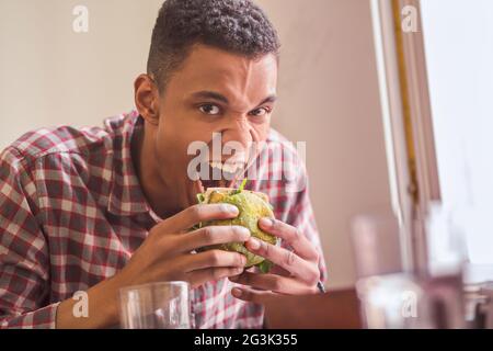 Man eating vegan burger en restaurant Banque D'Images