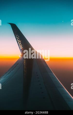 Fermer vue du logotype flydubai sur l'aile de l'avion. Avion à Sunset Sky. Vue depuis la fenêtre avion sur le vol en hauteur de l'avion. Voyages et Banque D'Images