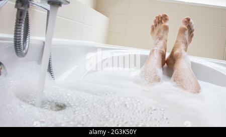 Les pieds des hommes dans une baignoire, accent sélectif sur les orteils Banque D'Images