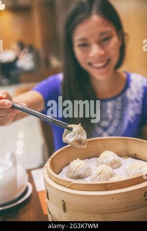 Restaurant chinois femme asiatique mangeant des boulettes de xiao long Bao soupe vapeur boulonnage de la nourriture locale sur voyage en Asie. Shanghai City Travel style de vie. Banque D'Images