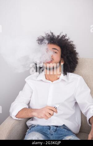 Hipster homme fumeur à la maison Banque D'Images