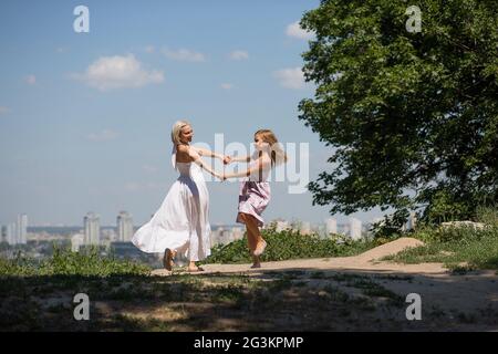 Maman et petite fille dansant dans le parc de la ville. Banque D'Images