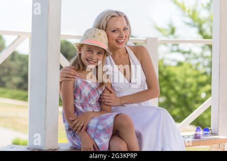Happy mother and daughter sitting on bench at. Banque D'Images
