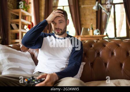 Emotional young guy with joystick in hands. Stock Photo