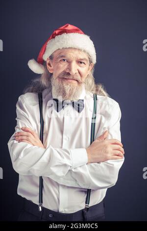 Un vieil homme portant un chapeau de père Noël. Banque D'Images