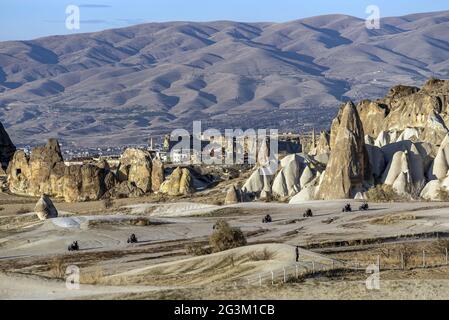 Touristes en VTT avec le paysage de cheminées de fées et de vignobles en Cappadoce, Turquie Banque D'Images