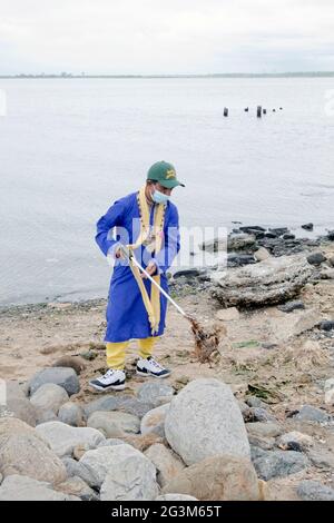 Un prêtre hindou se porte volontaire pour nettoyer la plage de Jamaica Bay dans Queens dans le cadre du projet de nettoyage de la plage de Prithvi en 2021. À Queens, New York. Banque D'Images