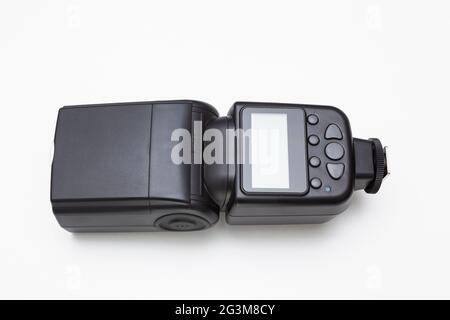 Flash speedlite sans fil pour la photographie sur fond blanc. Il est doté d'un écran d'affichage et de sept boutons gris pour différentes fonctions. Banque D'Images