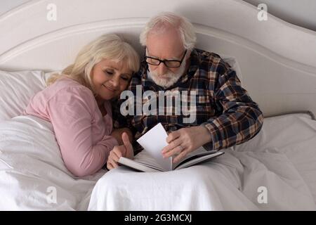 Vieux couple lire au lit. Banque D'Images