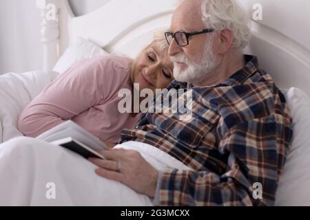 Vieux couple lire au lit. Banque D'Images