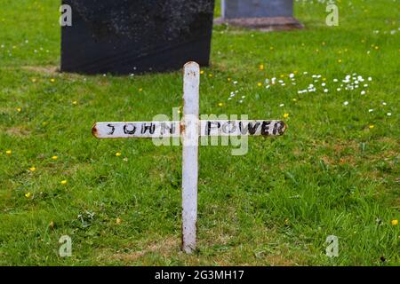 Petit marqueur de tombe en forme de croix dans un cimetière irlandais Banque D'Images