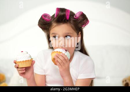 Cute girl eating cupcake. Banque D'Images