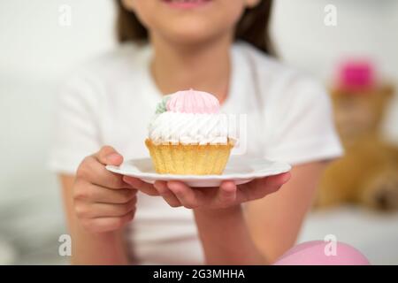 Cute girl eating cupcake. Banque D'Images