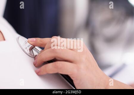 L'aide infirmière stéthoscope sur patient. Banque D'Images