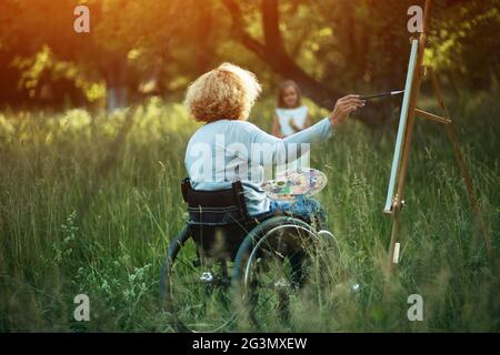 Femme en fauteuil roulant s'appuyant sur l'extérieur chevalet Banque D'Images