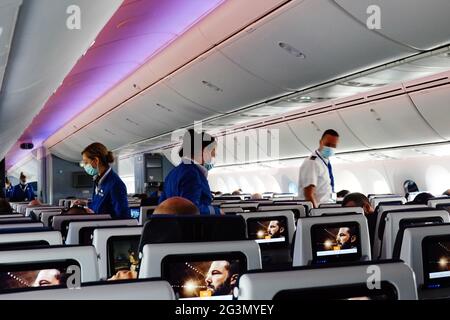 '24.03.2021, Amsterdam, Hollande-Nord, pays-Bas - les agents de bord traversent les rangées de sièges dans une cabine d'avion portant un protecteur de nez-bouche Banque D'Images