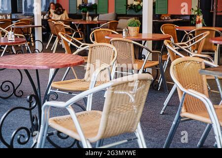 Café extérieur confortable en plein air. Chaises et tables en osier dans un restaurant en plein air vide. Lieu calme et romantique pour les réunions, les dates. Design rétro Banque D'Images