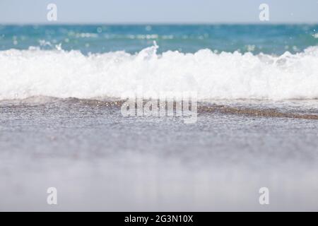 Grande et forte onde de tempête de couleur turquoise parsemée de moussage blanc et de pauses sur le rivage Banque D'Images