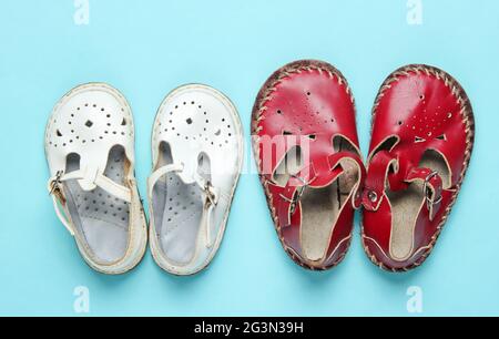 Deux paires de sandales en cuir pour enfants sur fond bleu. Vue de dessus Banque D'Images