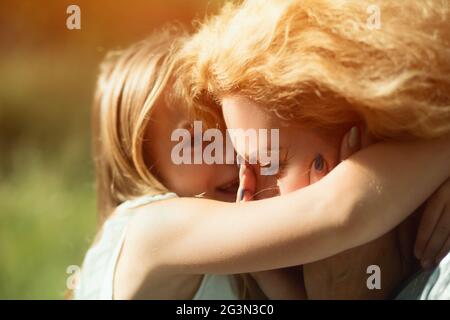 Close-up portrait of little daughter hugging sa mère handicapée Banque D'Images