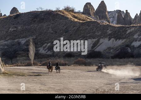 Les touristes en équitation sur les chevaux safari et ATV avec le paysage de cheminées de fées à Cappadoce, Turquie Banque D'Images