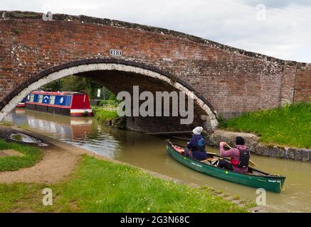 Deux personnes pagayez sur un canoë sous le pont 113 sur le South Oxford Canal Banque D'Images