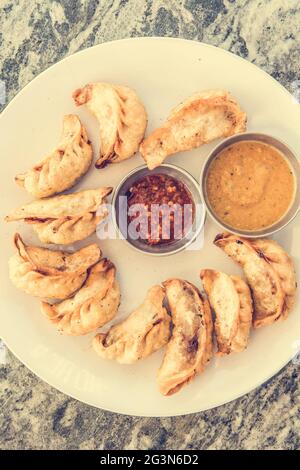 Assiette de momos traditionnels servie avec une délicieuse trempette. Banque D'Images