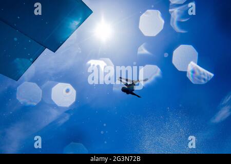 Cologne, Allemagne. 17 juin 2021. Un athlète de loisirs saute d'une tour de plongée de 7 1/2 mètres dans une piscine à la piscine du stade en plein soleil sur un ciel bleu. Credit: Rolf Vennenbernd/dpa/Alay Live News Banque D'Images