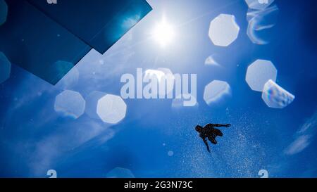 Cologne, Allemagne. 17 juin 2021. Un athlète de loisirs saute d'une tour de plongée de 7 1/2 mètres dans une piscine à la piscine du stade en plein soleil sur un ciel bleu. Credit: Rolf Vennenbernd/dpa/Alay Live News Banque D'Images