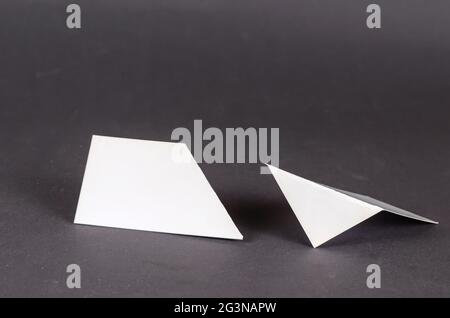 Composition géométrique abstraite de différentes formes blanches sur fond gris. Deux formes géométriques avec des angles droits et aigus uniquement. Mise au point sélective. Banque D'Images