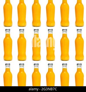 certaines bouteilles en verre remplies d'une boisson aux fruits et légumes de couleur orange disposées en lignes formant une mosaïque sur un fond blanc Banque D'Images