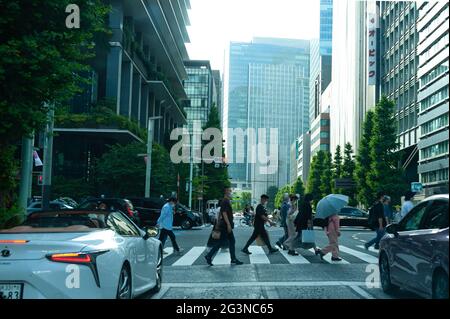 Shinjuku City, Tokyo, Japon - 12 juin 2021 : des piétons japonais portant un masque traversant un passage en croix. Banque D'Images