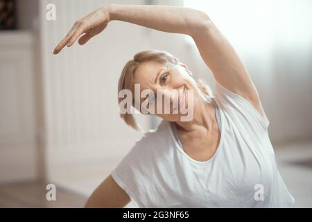 Des cours de yoga à la maison de belles femmes de plus de 50 ans. Banque D'Images