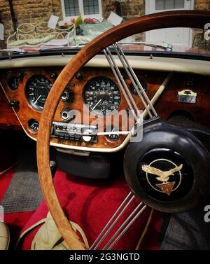 L'intérieur d'une voiture classique avec tableau de bord en bois et volant Banque D'Images