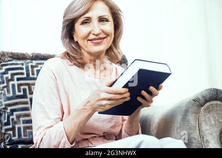 Belle femme mature est en train de lire un livre Banque D'Images