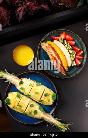 Le concept d'une alimentation saine. Assiette de fruits et de baies - pomme, orange, banane, kiwi, fraise, menthe Banque D'Images